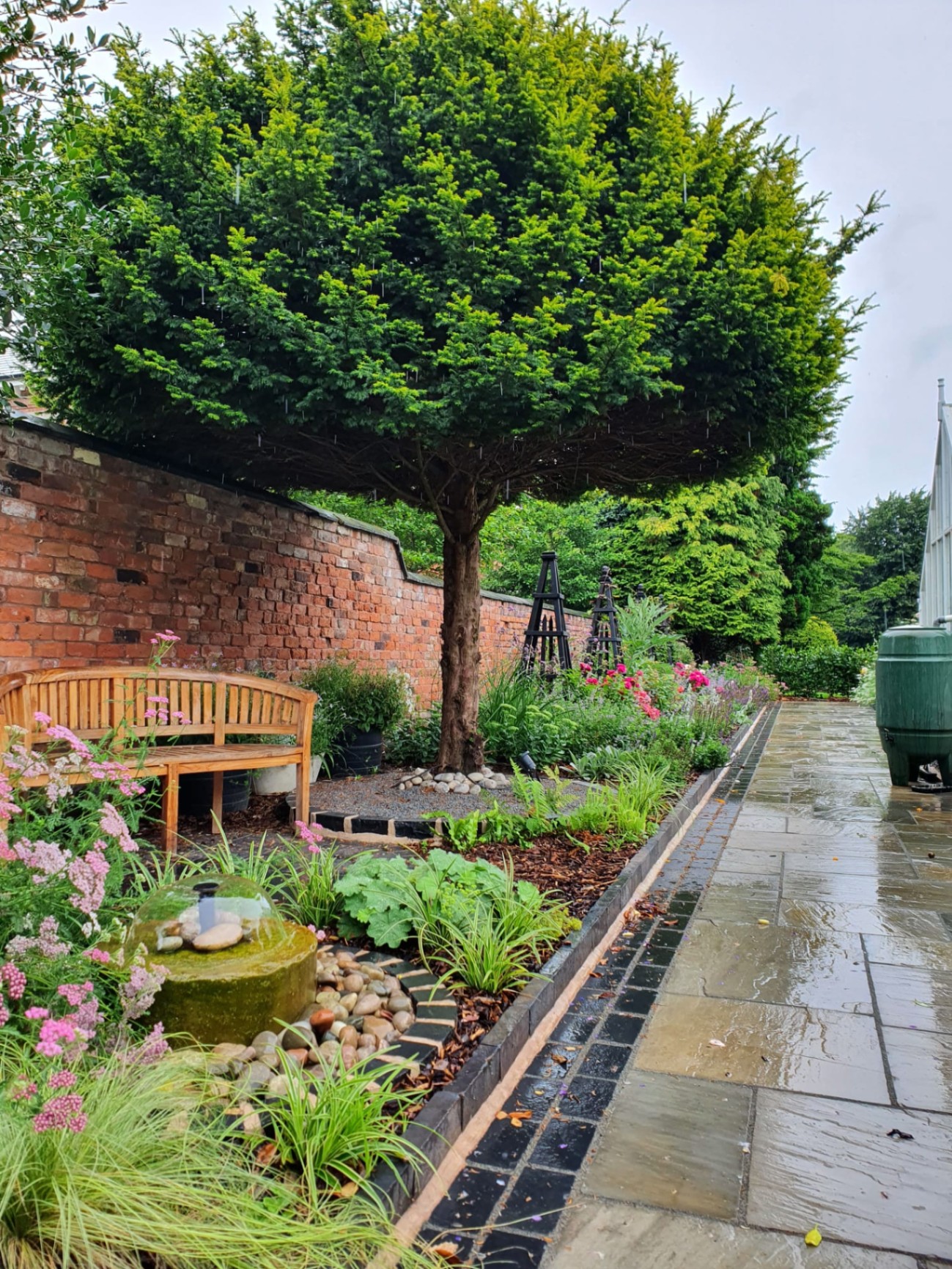 Walled garden with bench, water feature and sandstone path